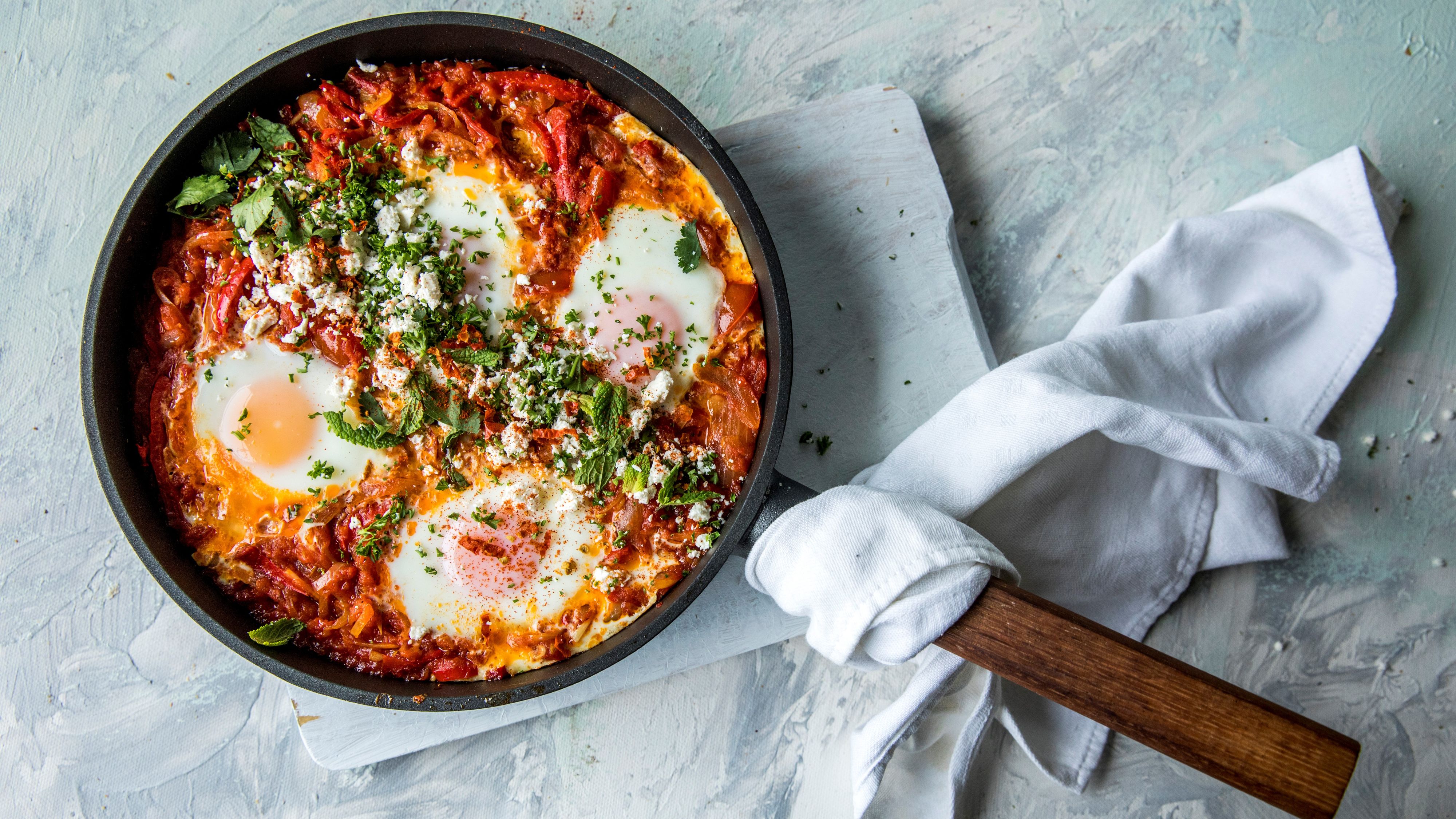 shakshuka i en stekepanne på en lys bakgrunn