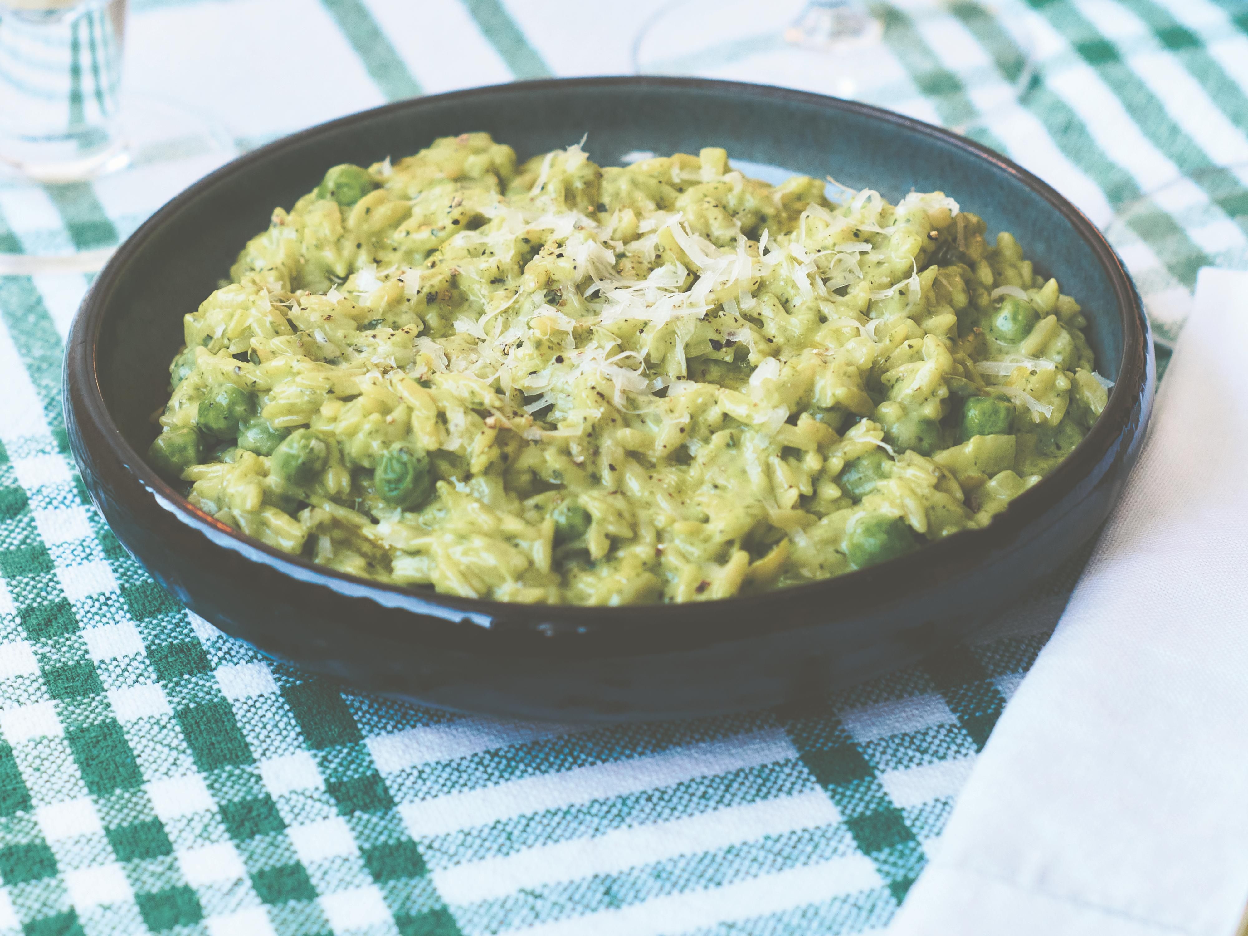 Risoni med purre, mynte og erter i blågrønn, dyp tallerken.