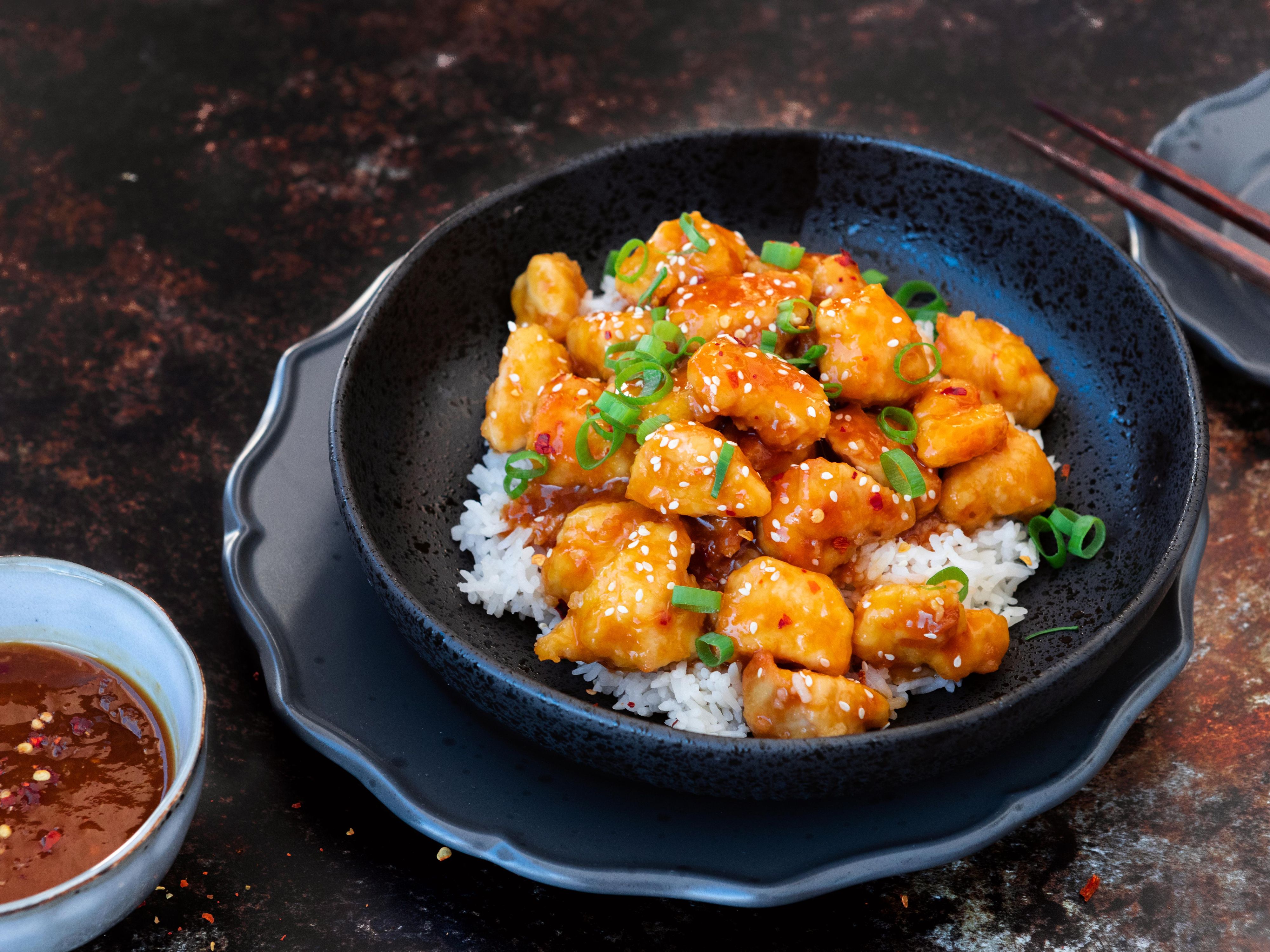 Appelsinkylling toppet med sesamfrø og vårløk servert med ris