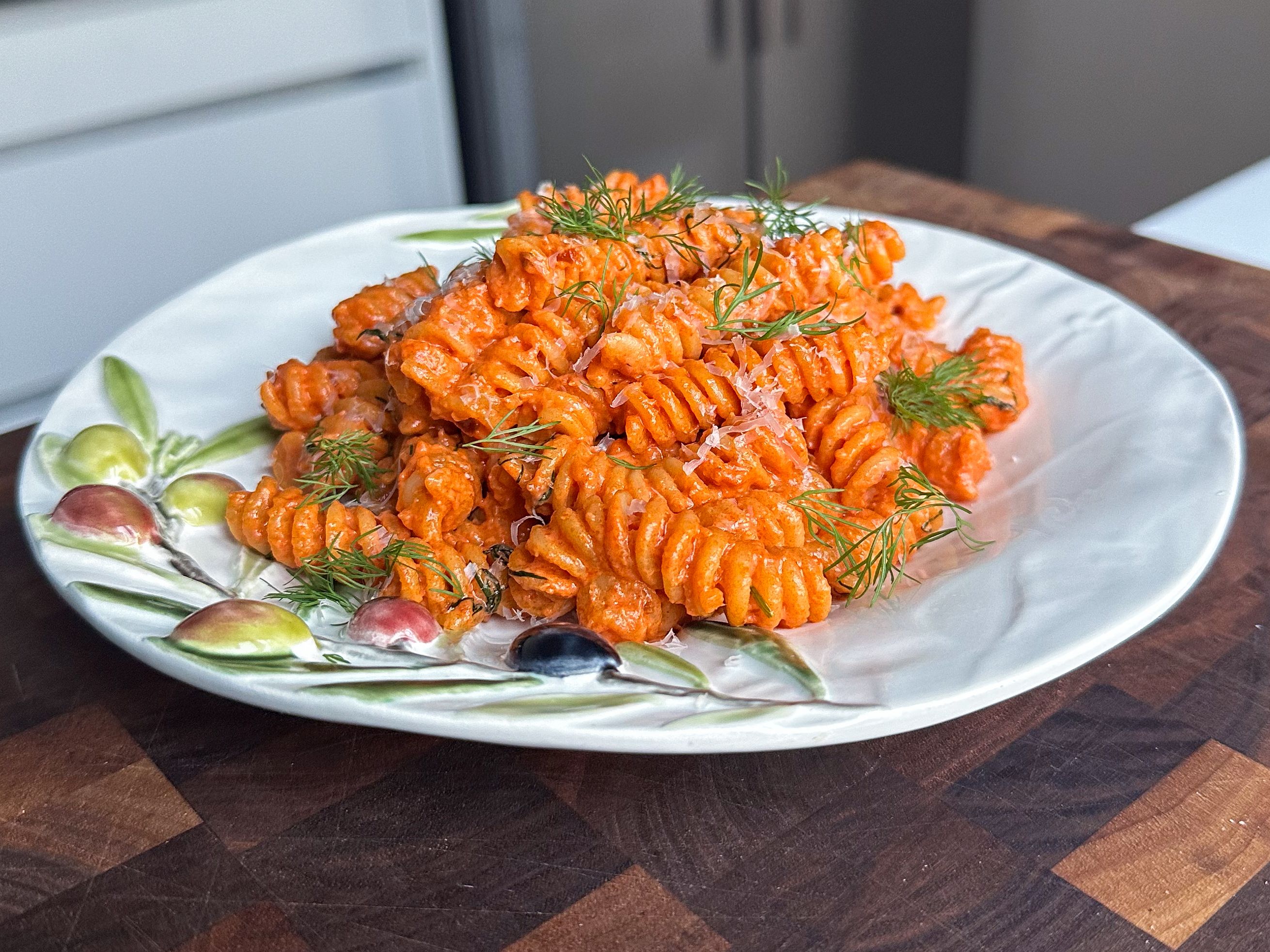 Akevittpasta med basilikum og dill på hvit tallerken med mønster