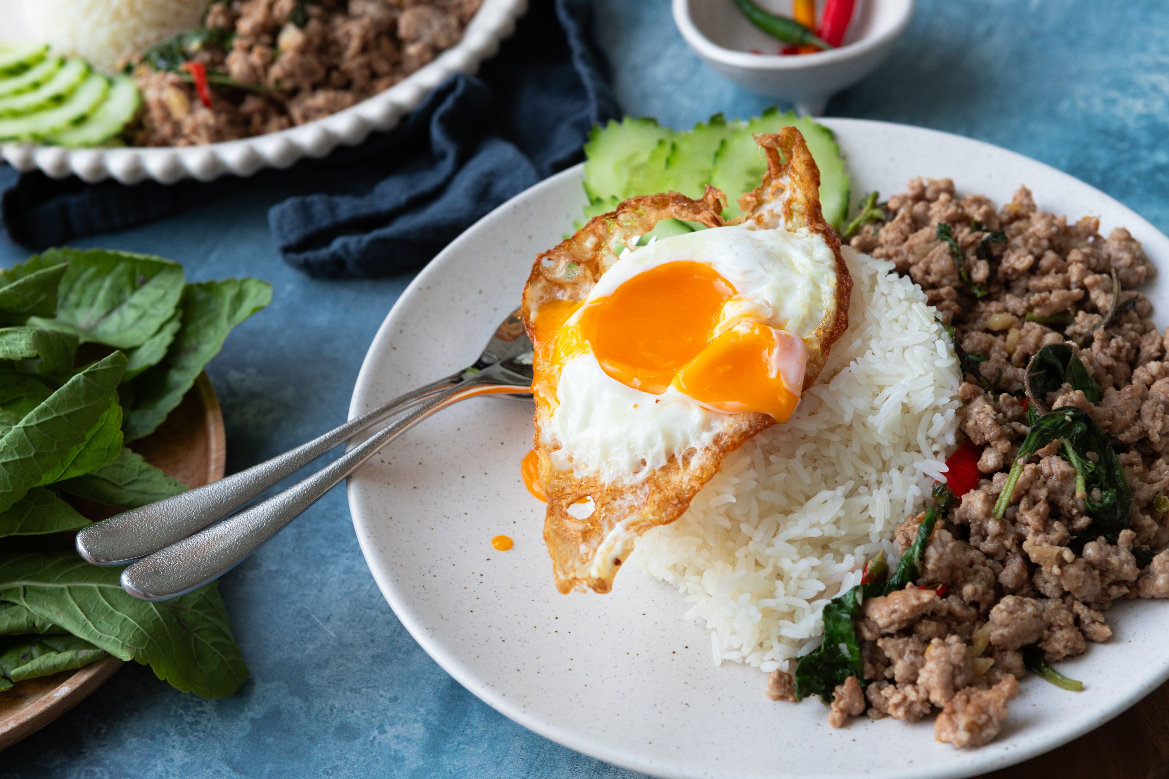 Pad kra pao på hvit tallerken.