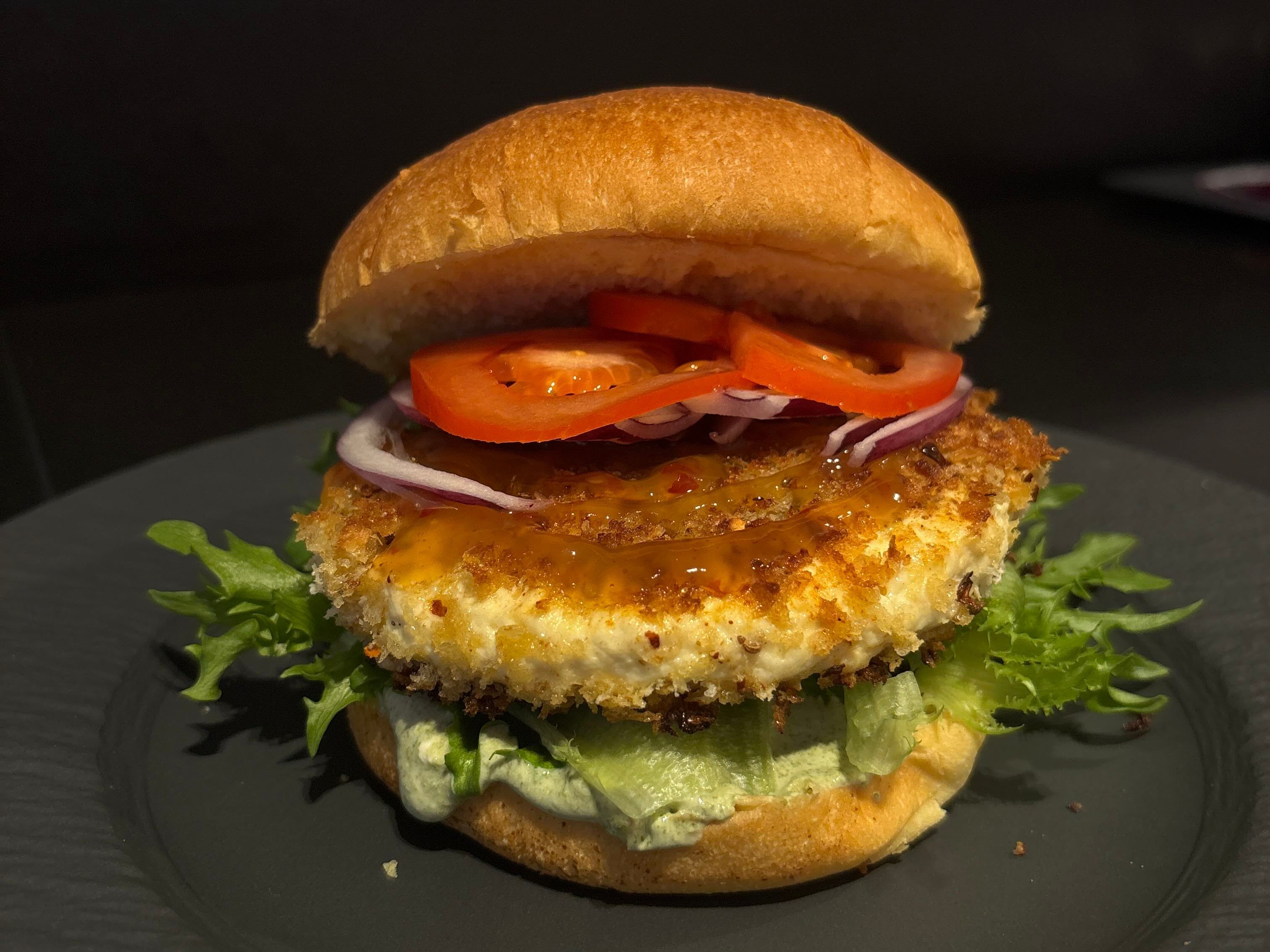 Paneer-burger på stort, sort fat.