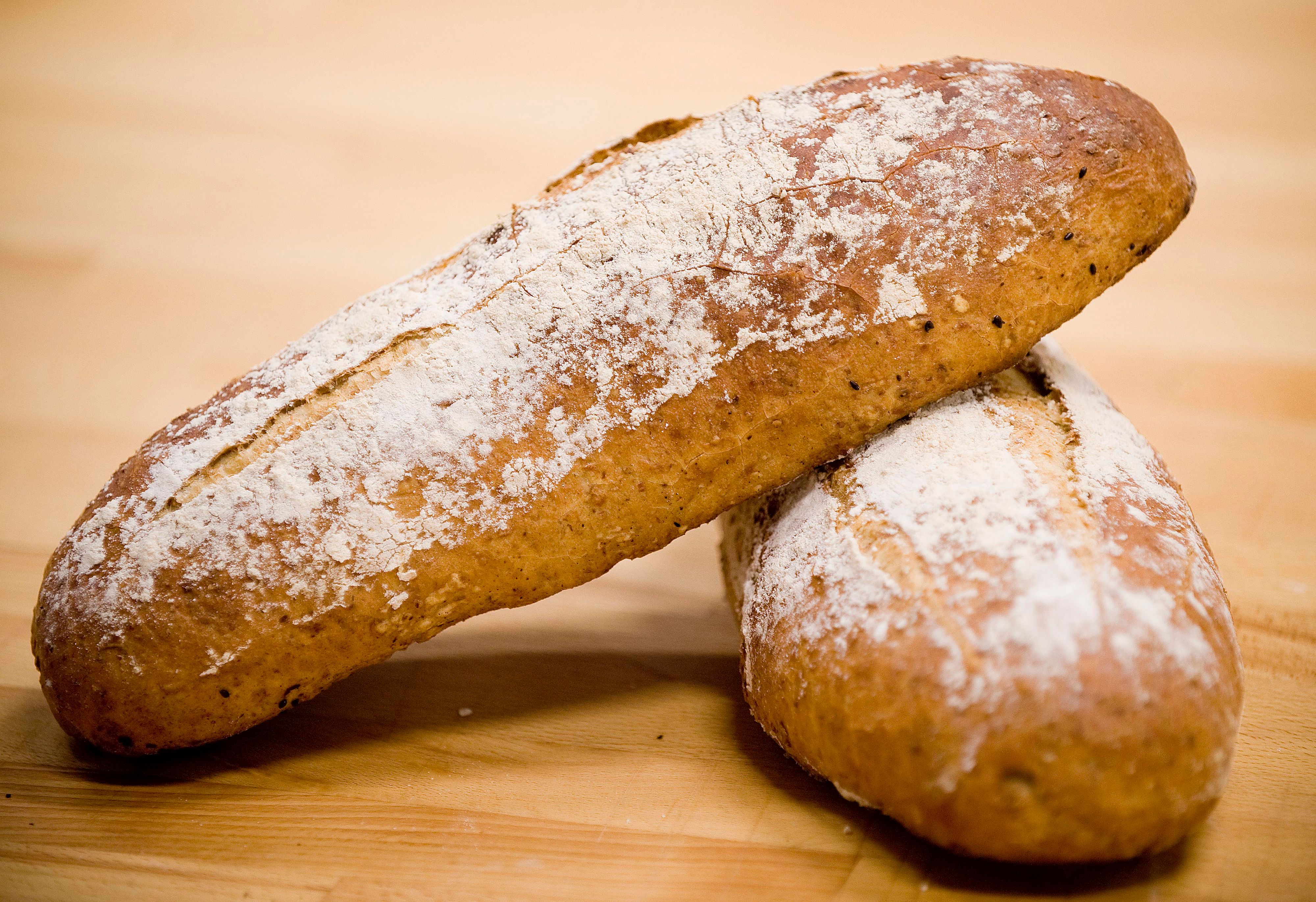 To ferdigstekste brød ligger på en kjøkkenbenk i tre