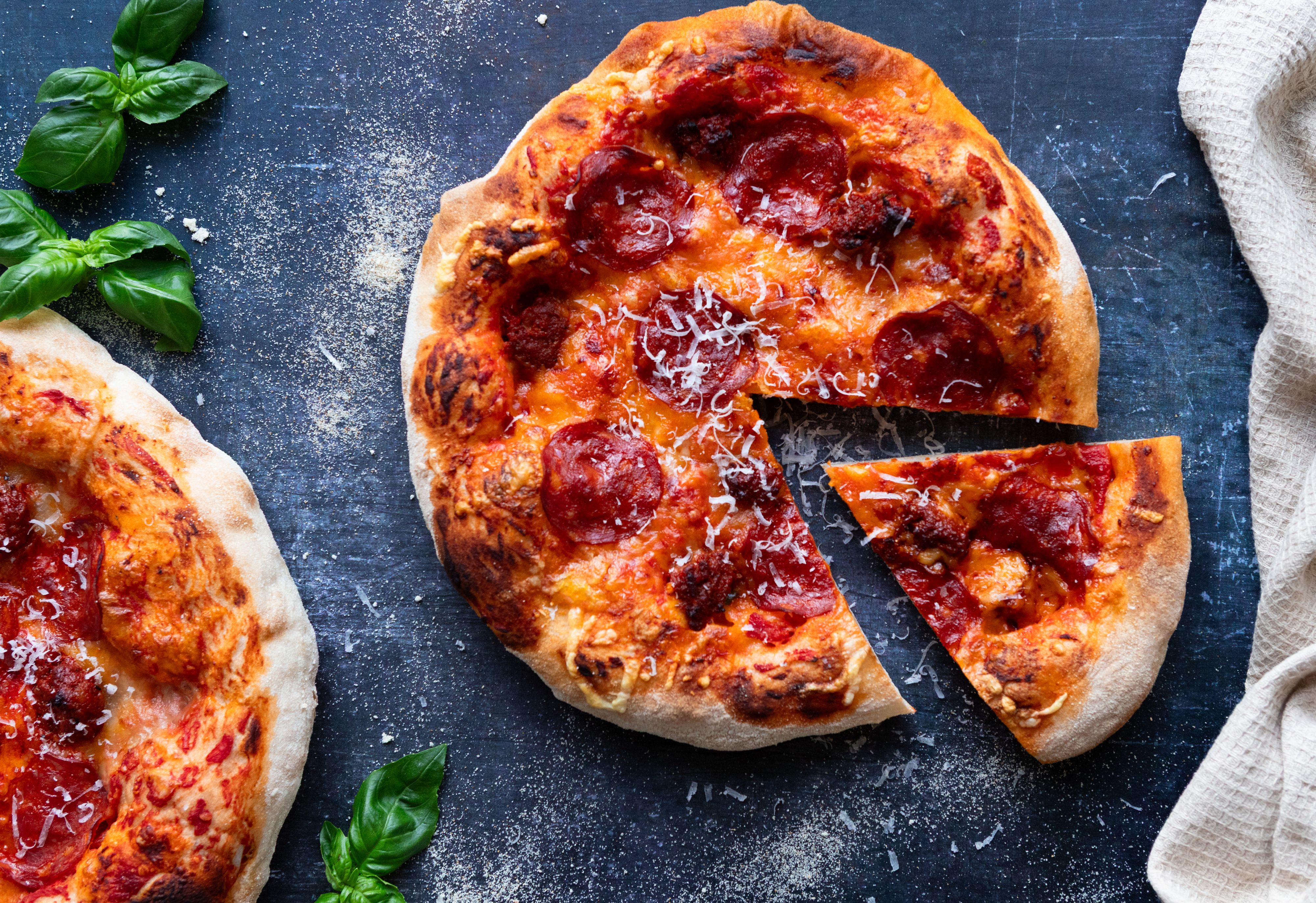 Diavola-pizza på svart benkeplate.