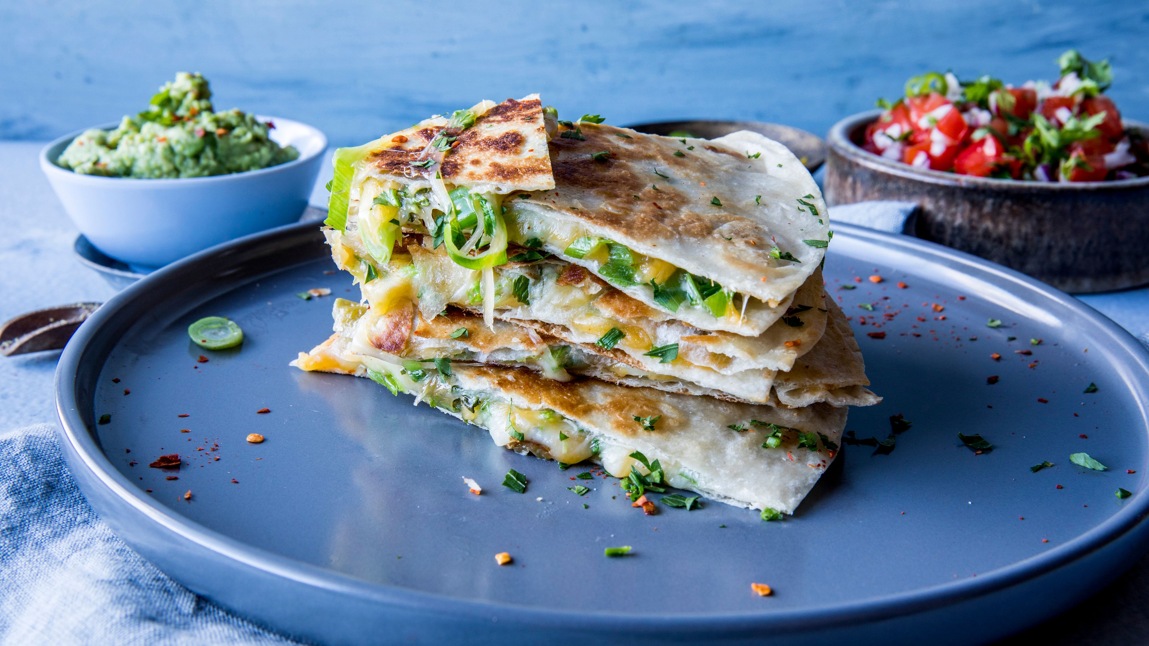 Quesadilla med guacamole på rund, blå tallerken.