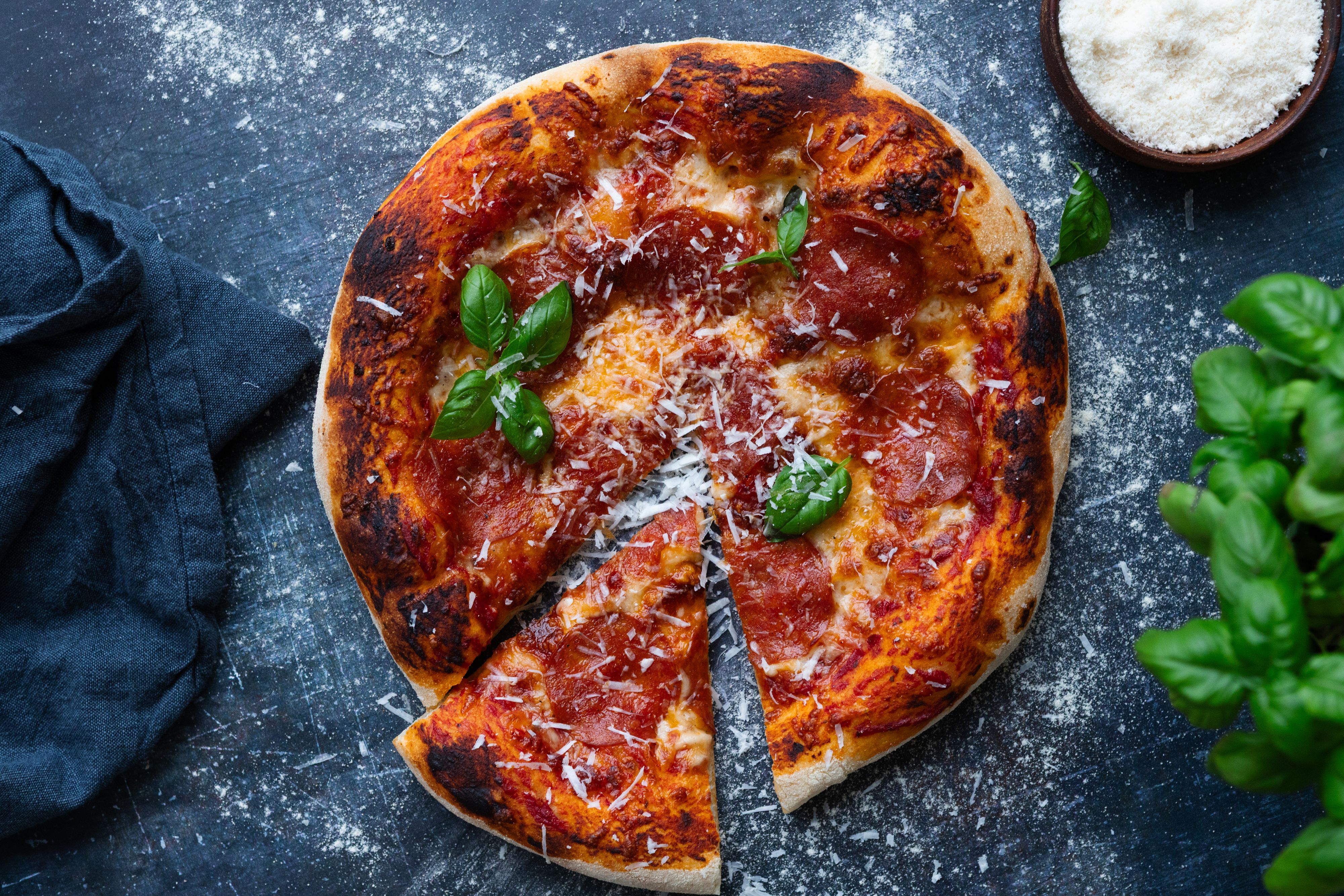 Pepperonipizza på grå steinbenk.